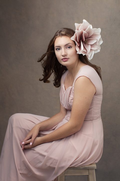 High school senior photo of Lindsay wearing pink with a large pink flower in her hair