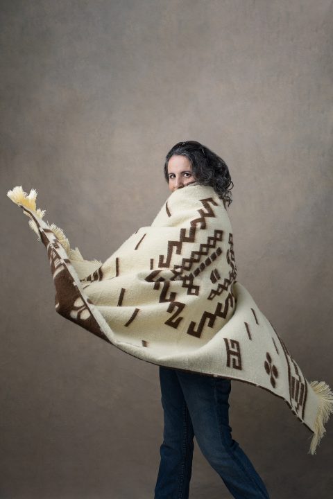 Photo of a woman dancing, wrapped in a blanket