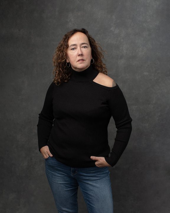 Portrait of singer-songwriter Audrey Drake, wearing a black top and jeans