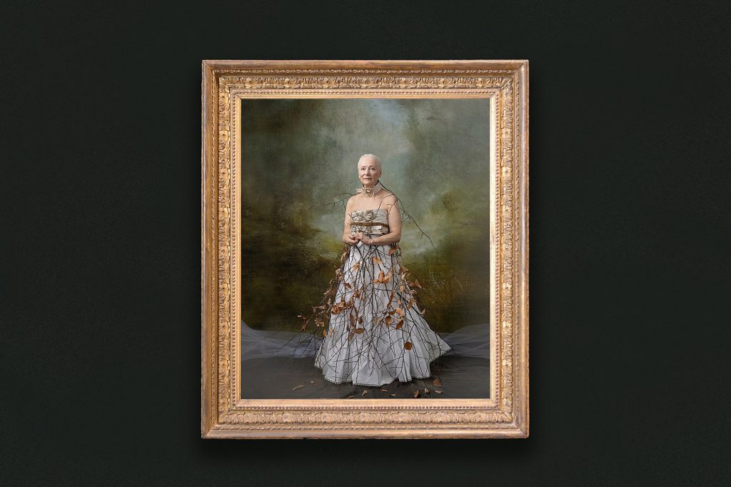 A gold framed wall portrait of Rebecca wearing an outfit made of twigs