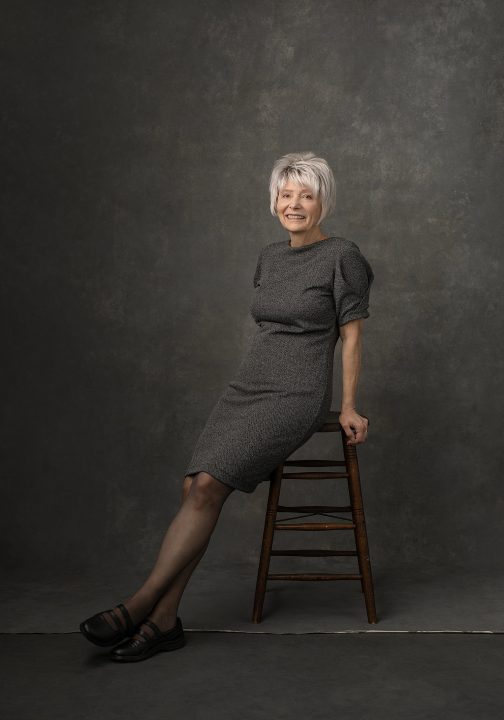 Portrait of Rebecca wearing a tweed dress, smiling