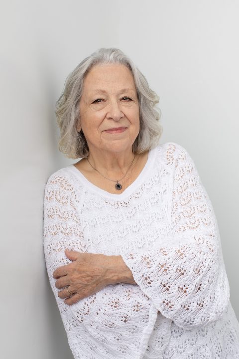 High key portrait of Liz, wearing a textured sweater, for the Over 50 Revolution photo session