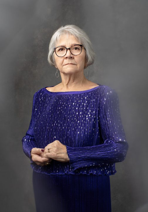 Portrait of Rebecca from her photo session for Extraordinary: the Over 50 Revolution. She is wearing a purple dress, with a motion-blurred background