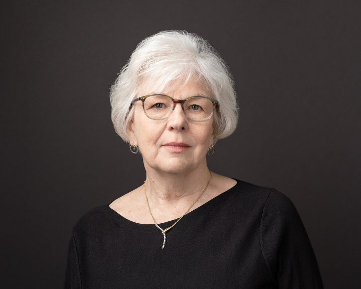 Headshot of quilter Susan Hofstetter in front of a black background