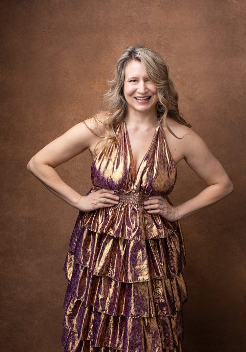 Portrait of Amanda, laughing, wearing a shiny copper dress for Extraordinary: the Over 50 Revolution