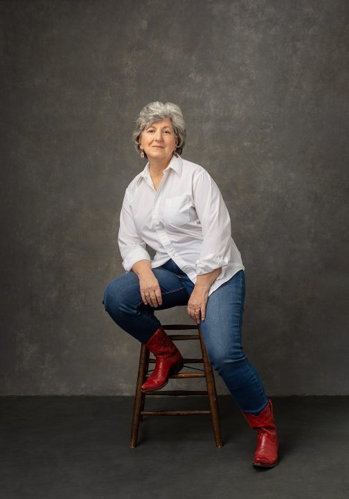 Susan C. wearing jeans and red cowboy boots for her Extraordinary: the Over 50 Revolution portrait session