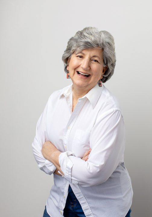 Portrait of Susan C., laughing, wearing a white shirt