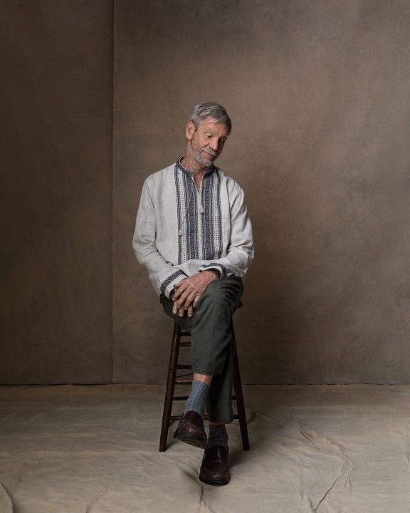 ©Maundy Mitchell - Portrait of Alex Ray, wearing a Ukrainian shirt, seated and looking down