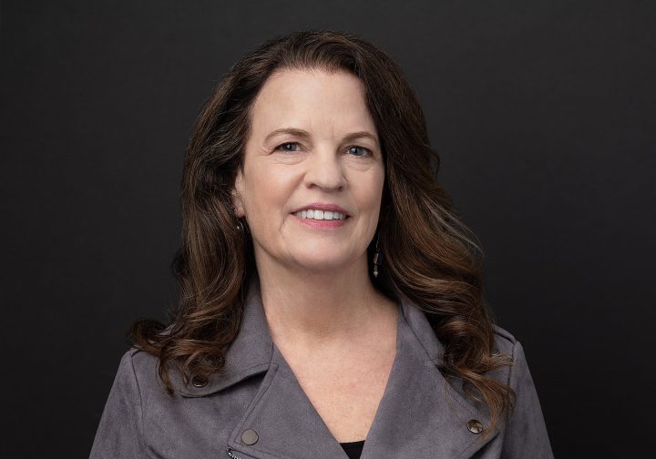 A headshot of Heidi with a dark background