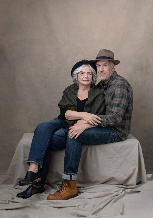 Portrait of a couple, seated, wearing hats