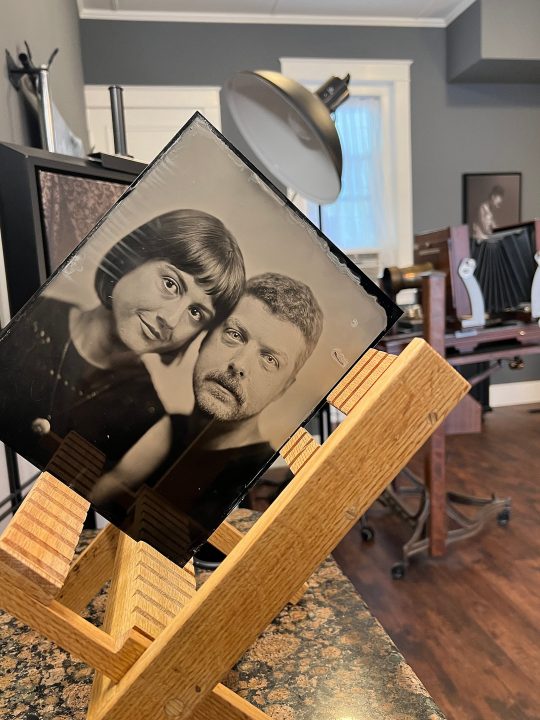An 8x10 tintype portrait of Rebecca and Jonathan, in the drying rack