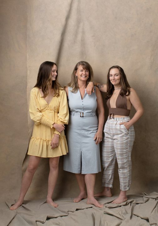 A portrait of a mother and daughters, wearing casual outfits