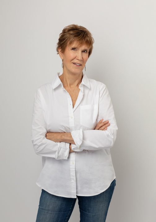 A portrait of Jyl, wearing a white shirt and jeans