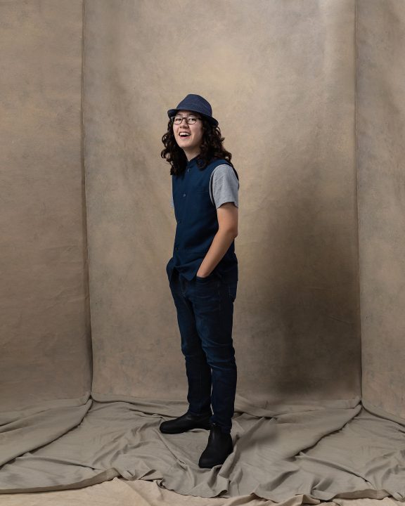 Portrait of David wearing a hat and waistcoat, laughing