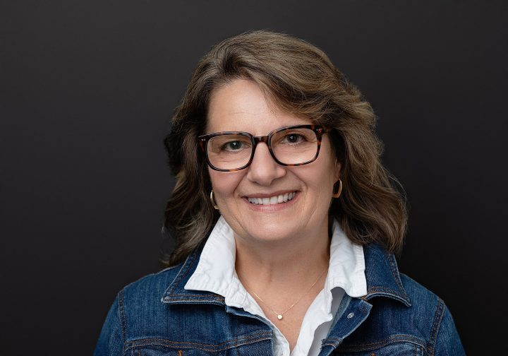 Headshot of Beth in front of black background