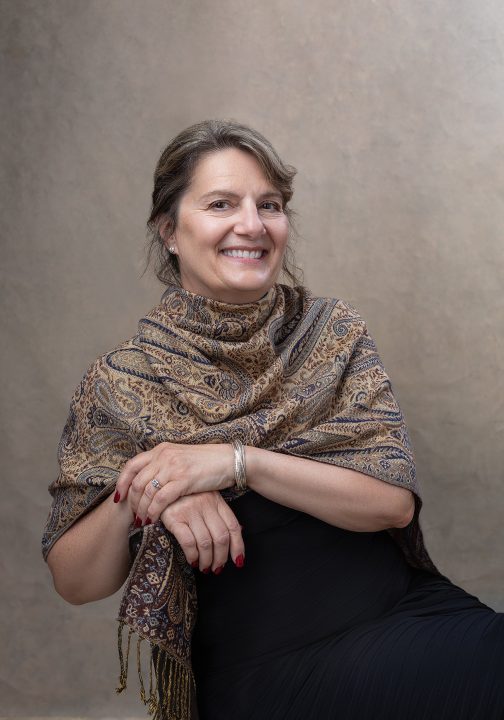 Portrait of Beth, seated, wearing a scarf, for the Over 50 Revolution