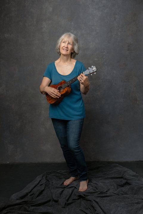 Portrait of Judith for Extraordinary: the Over 50 Revolution. She is playing the ukulele