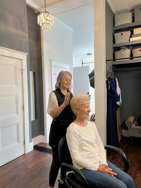 Behind the scenes cell photo of Debbie, enjoying professional hair and makeup styling by Dianne Sitar for her portrait session for Extraordinary: the Over 50 Revolution