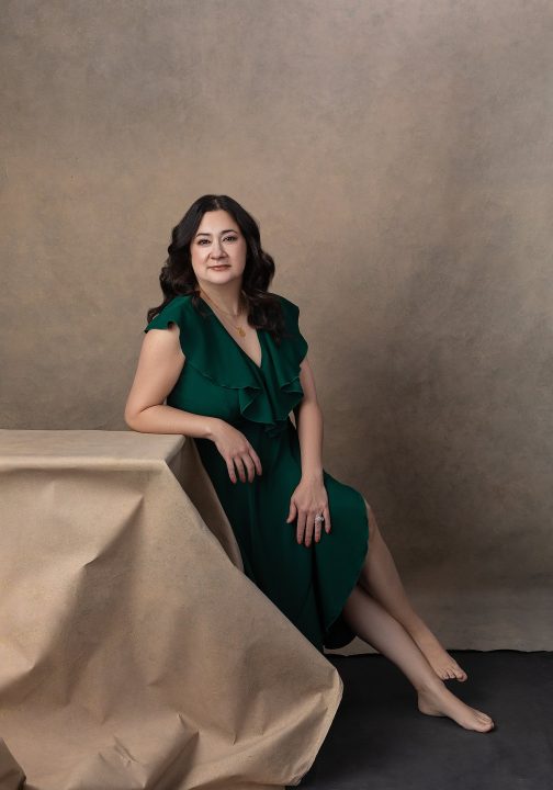 Cindy, wearing a green dress for her family portrait session