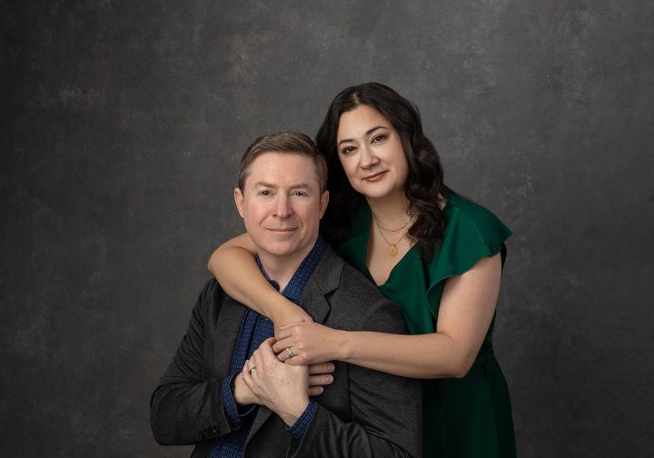 Photo of a couple in front of a hand-painted gray backdrop