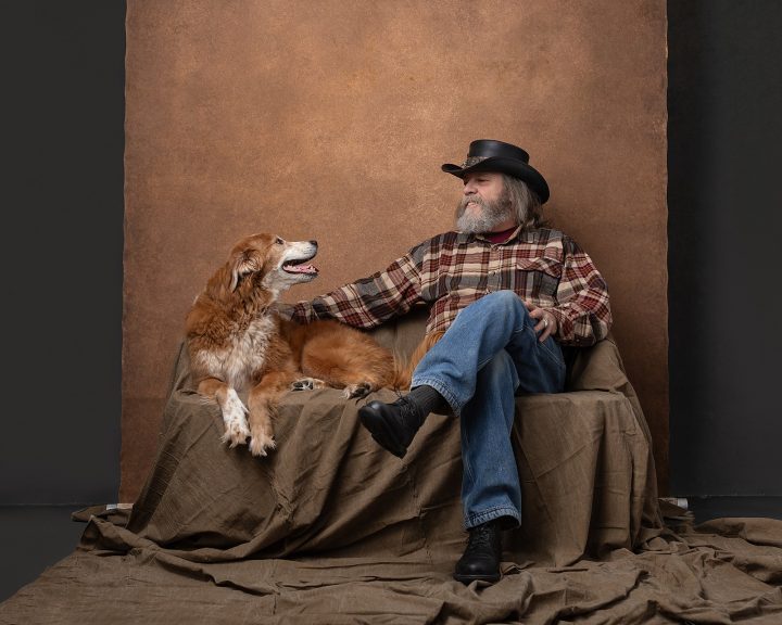 Casual portrait of Mark with dog Marley on a sofa