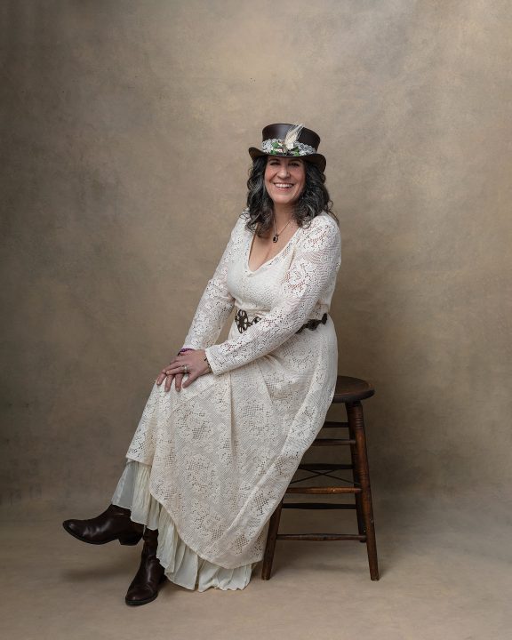 Portrait of Christine wearing lace wedding gown and steampunk hat