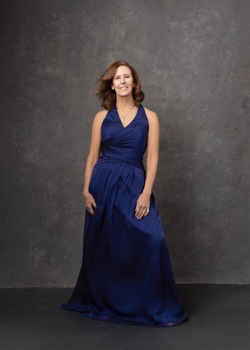 A portrait of Robin wearing a blue halter gown for The Over 50 Revolution 2024