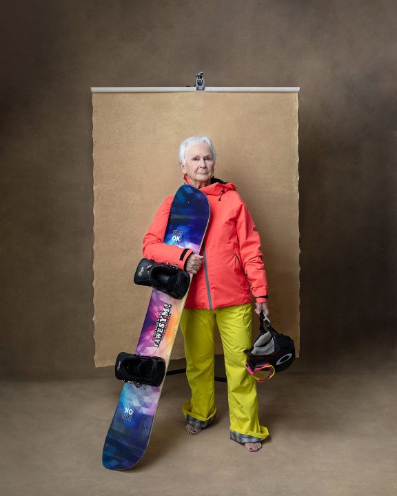 A portrait of a 80-year-old woman snowboarder, Ginny, for The Over 50 Revolution photo session