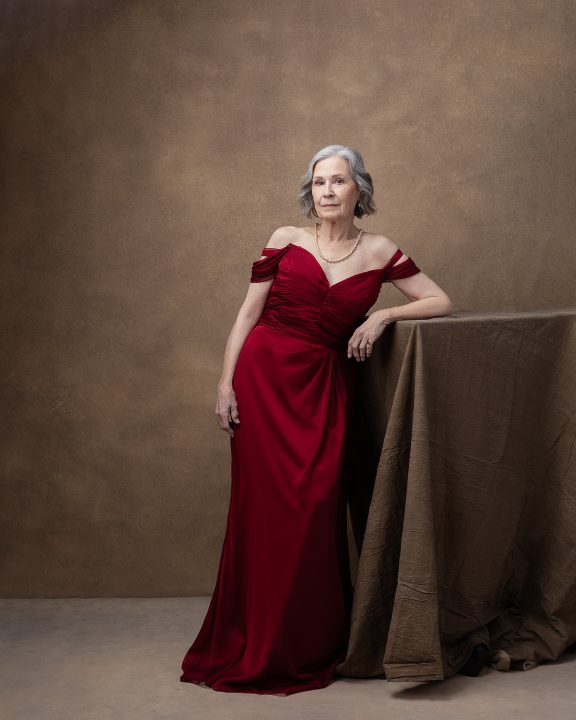 Portrait of Georgia wearing a red silk gown for The Over 50 Revolution