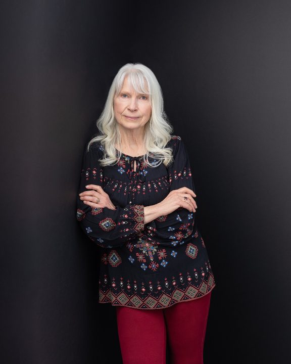 A portrait of Joann, in front of a black background, from her photo session for The Over 50 Revolution at Maundy Mitchell Photography