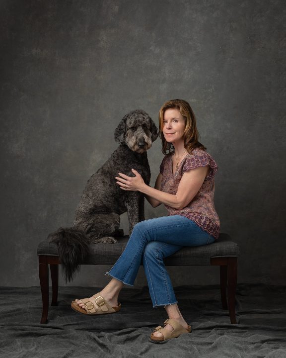 A casual portrait of Debra sitting with her dog