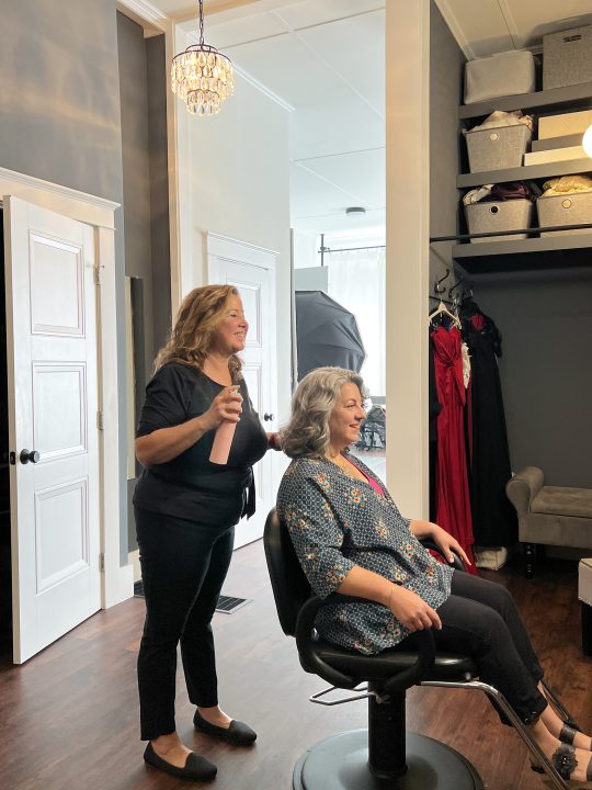 Behind the scenes photo of Rebecca, enjoying hair and makeup styling as part of her session for The Over 50 Revolution