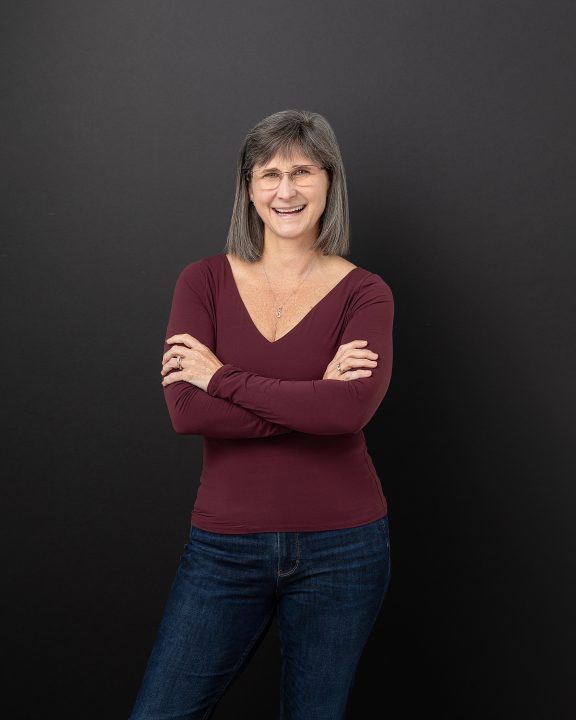 A casual branding portrait for Melinda Johnston, Physical Therapist, against a black background