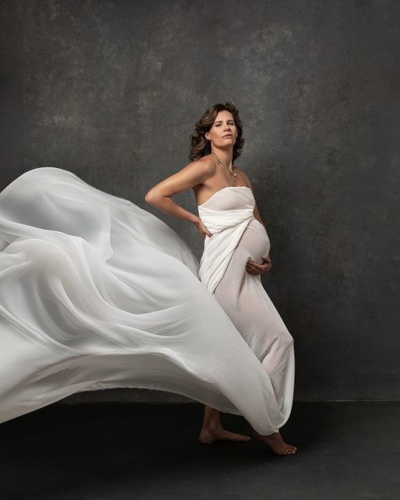 Maternity portrait of Hally wrapped in long, flowing, white silk fabric