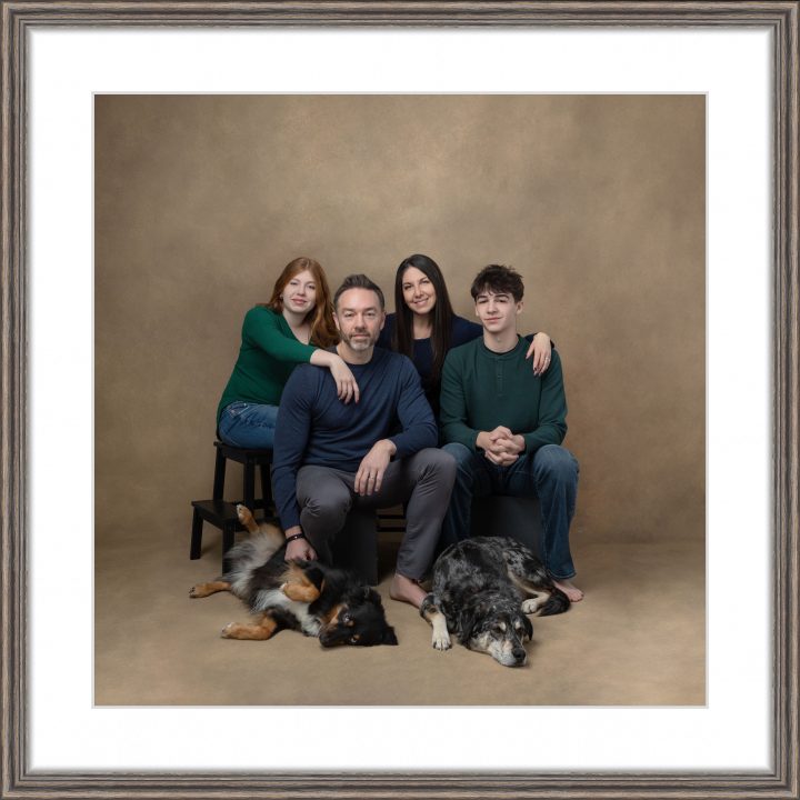 Framed wall art of a family portrait with dogs