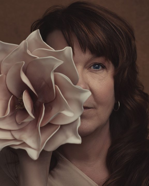 Closeup portrait of Kree with a large flower covering half her face