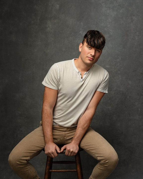A portrait of Maxwell, seated and leaning, for his first modeling portfolio